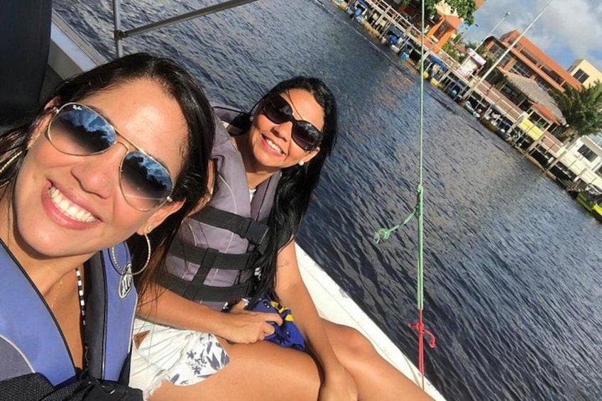 Two people on a boat with a waterway and buildings in the background. 5