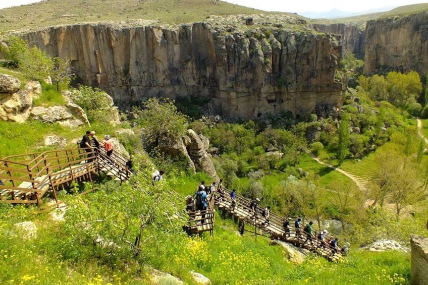 Un canyon avec des passerelles en bois et des personnes qui font de la randonnée. 1