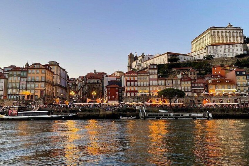 A riverside cityscape with historic buildings, a bridge, and boats. 2