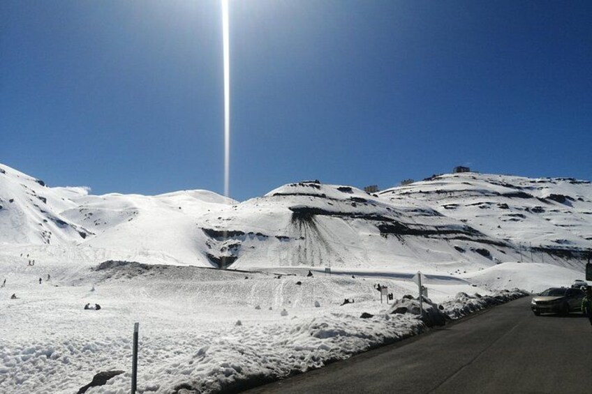 Eine verschneite Berglandschaft mit einer Straße und einem Fahrzeug. 3