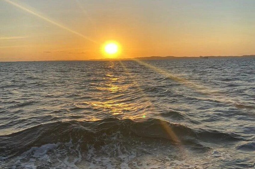 A sunset over the ocean with waves reflecting the sun's light. 3