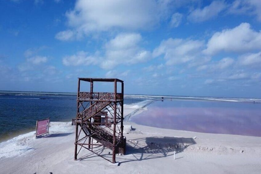 Et redderfyr på en strand med et roligt hav og en klar himmel. 4