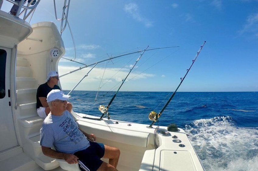 A boat with two people fishing, calm sea, clear sky. 3