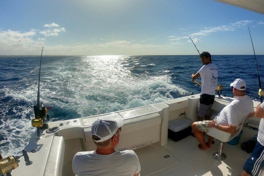 A boat with people fishing in the ocean. 5