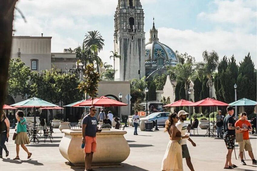 A public square with a large fountain, palm trees, and a historic building with a dome. 3