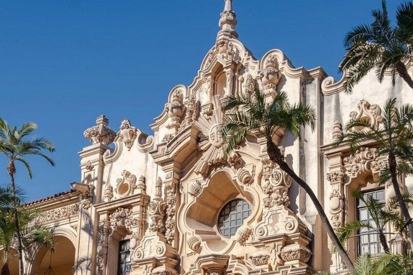 A historic building with ornate architecture, palm trees, and clear blue sky. 5