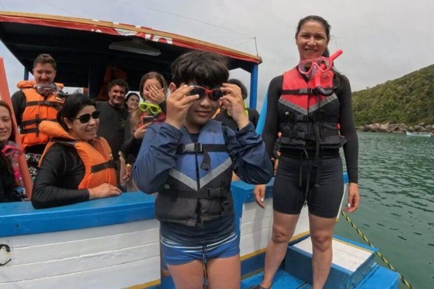 People on a boat wearing life jackets and snorkeling gear. 2