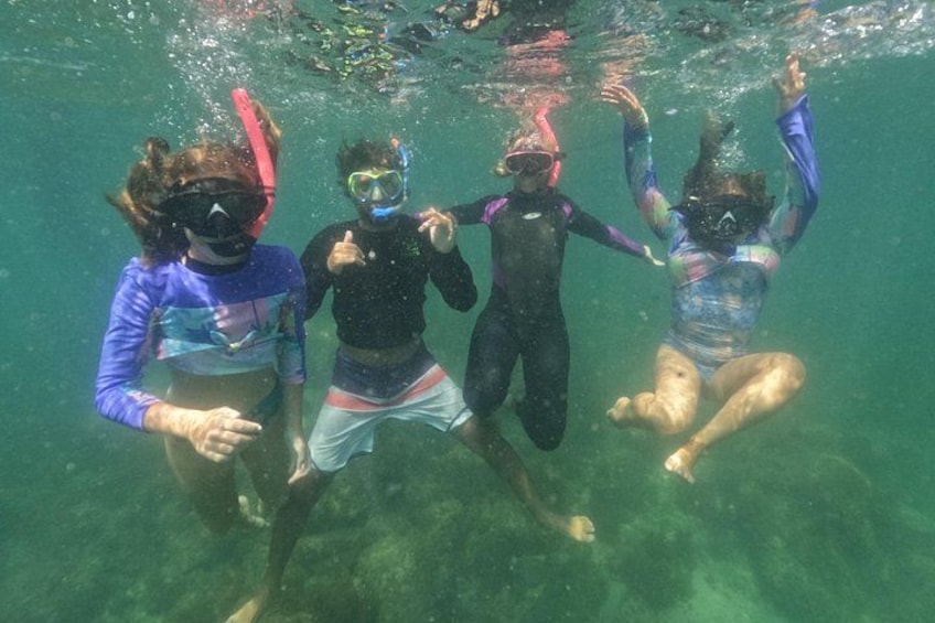 Four people snorkeling underwater. 1