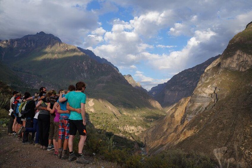 A group of hikers on a mountain trail with steep cliffs and a valley. 2