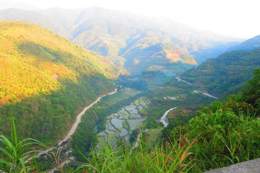 A river winding through terraced fields in a mountainous valley. 1