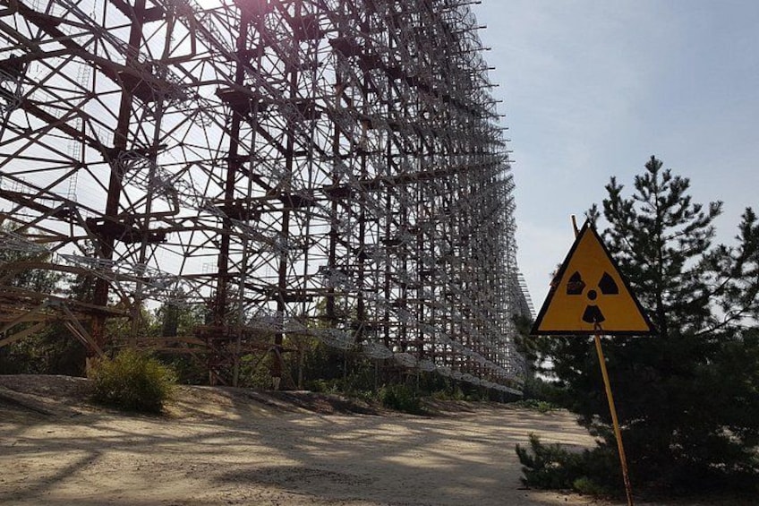 A construction site with a large metal framework and a radiation warning sign. 3