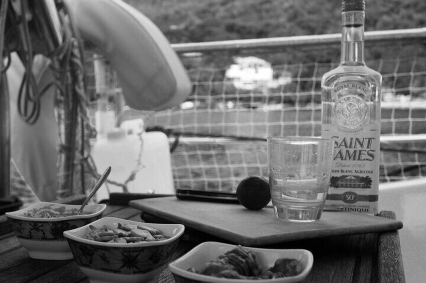 A bottle of Saint James gin, a glass, and bowls of food on a wooden table. 5