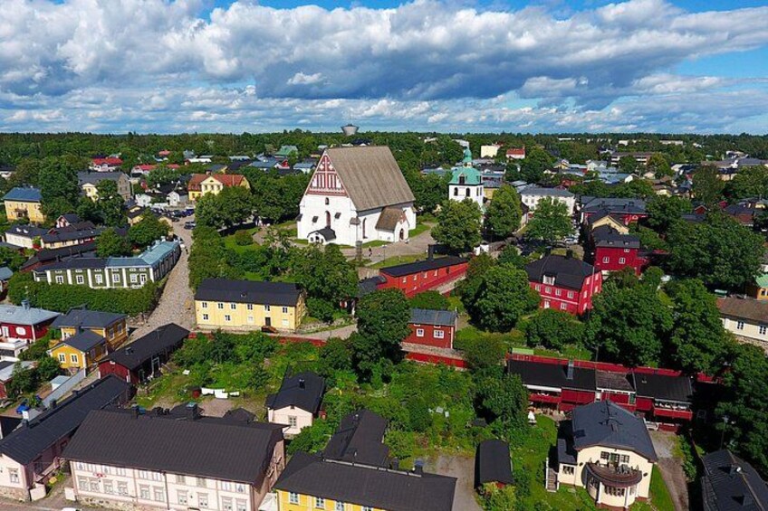 A town with a prominent church, various residential buildings, and surrounding greenery. 1