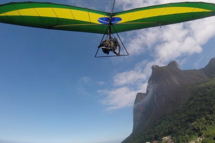 Un parapente aux ailes vertes et jaunes, survolant un paysage montagneux. 3
