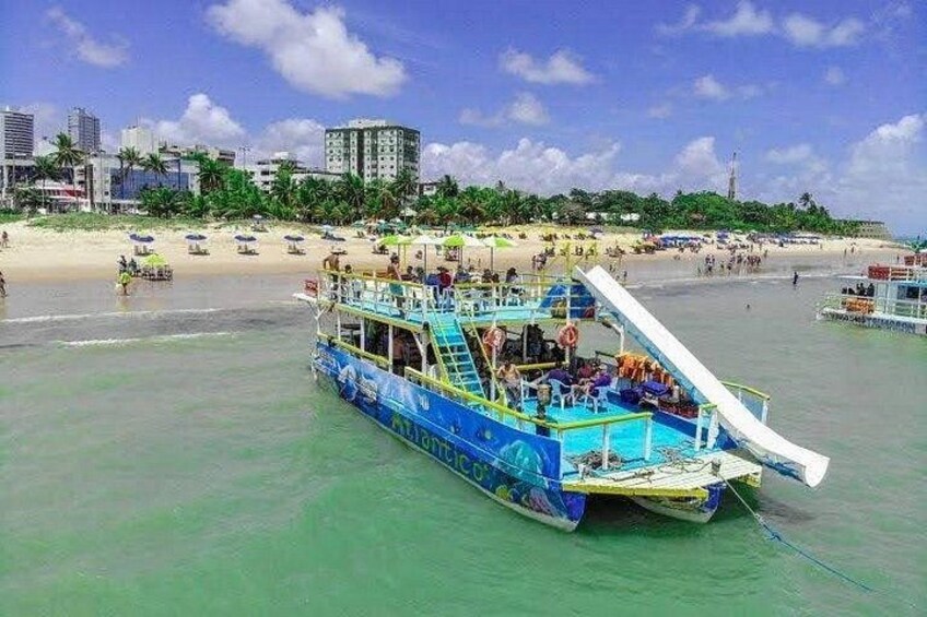 A colorful boat on a beach with a city skyline in the background. 2
