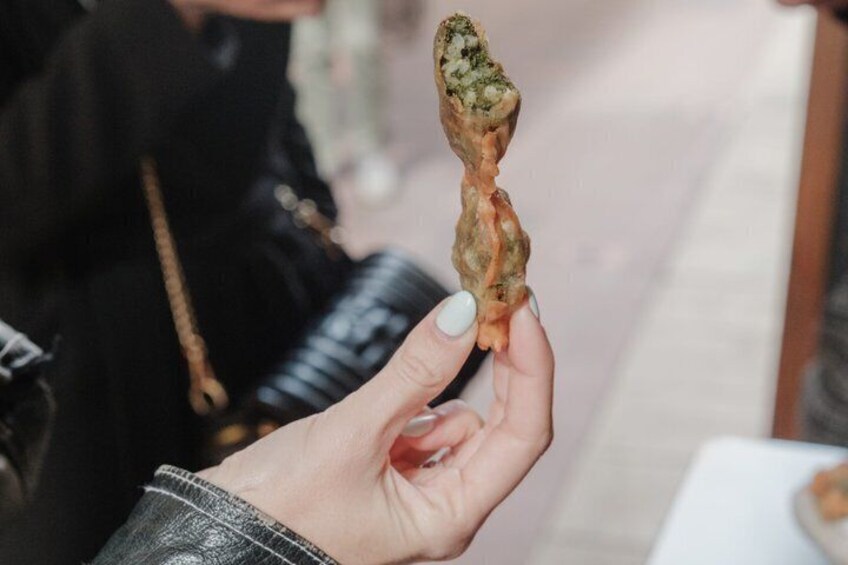 A hand holding a fried food item. 1