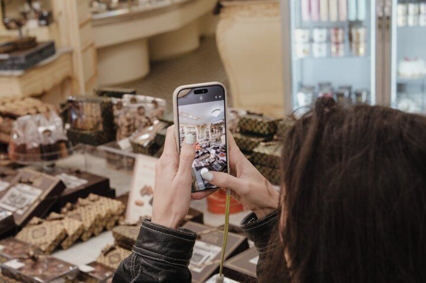 A person taking a photo of a chocolate display in a store. 2