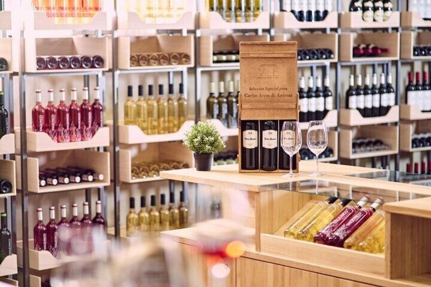 A wine store with wooden shelves filled with various bottles of wine. 5