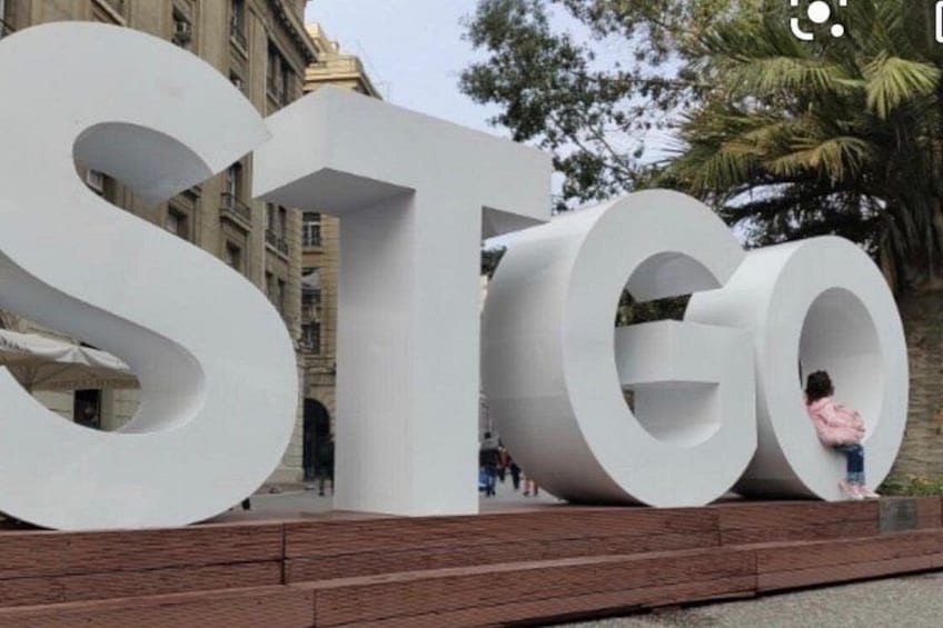 De grandes lettres blanches formant le mot « STGO » sont disposées sur une plateforme dont le sol est en bois. 4