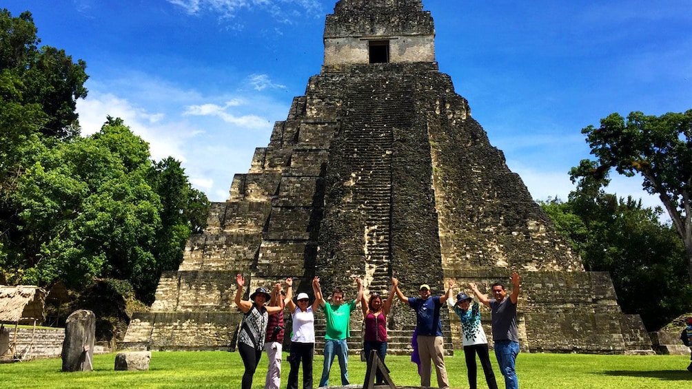 Group posing in front of tall temple in the ancient Mayan settlement of Tikal 5