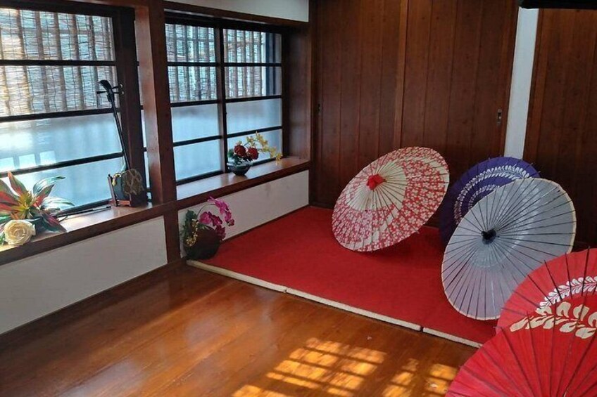 Ett traditionellt japanskt rum med tatamimattor på golvet, skjutdörrar av trä och en röd matta. 5