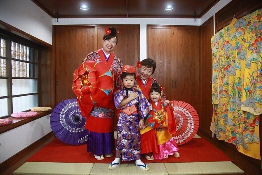 Ett traditionellt japanskt rum med skjutdörrar av trä, tatamimattor och färgstarka kimonos. 2