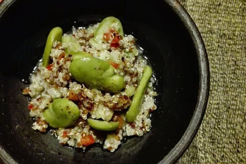 Un tazón negro con quinoa, verduras verdes y pimientos rojos. 2