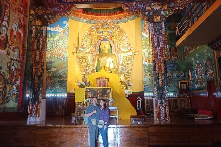Un'imponente statua dorata in un tempio, con murales elaborati e decorazioni colorate. 3