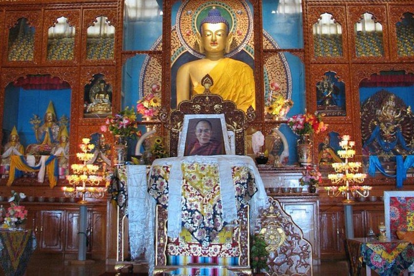 A religious shrine with a large Buddha statue, ornate decorations, and various religious artifacts. 2