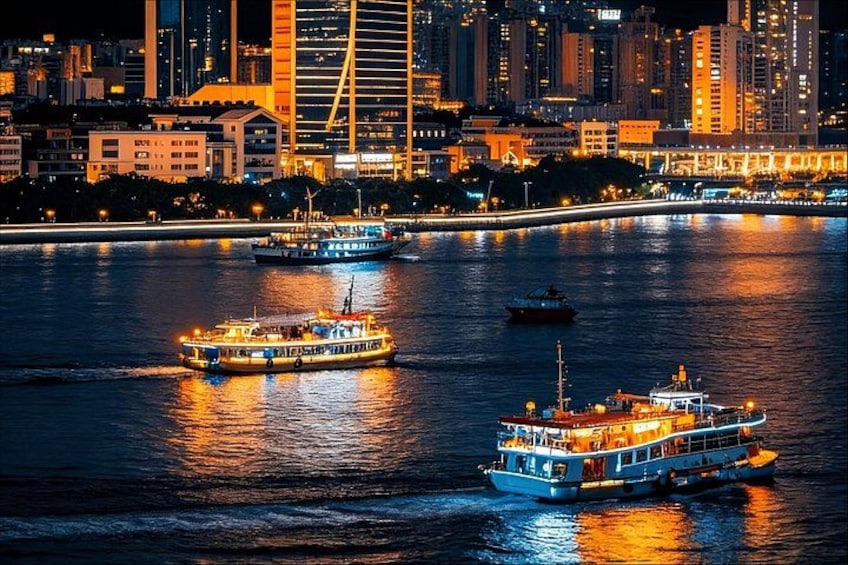 Un paisaje urbano nocturno con edificios iluminados y dos barcos en el agua. 1