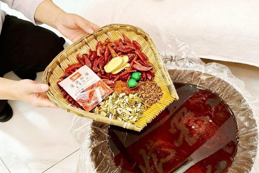 Une personne tenant un panier rempli d’aliments séchés et un paquet, au-dessus d’un récipient recouvert de plastique. 2