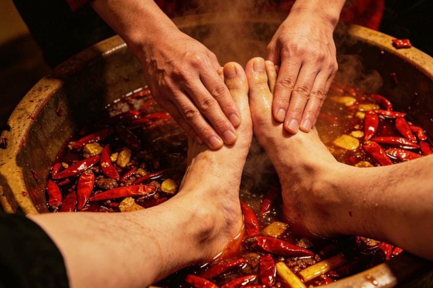 Des mains plongeant dans un récipient contenant des piments rouges et des épices. 1