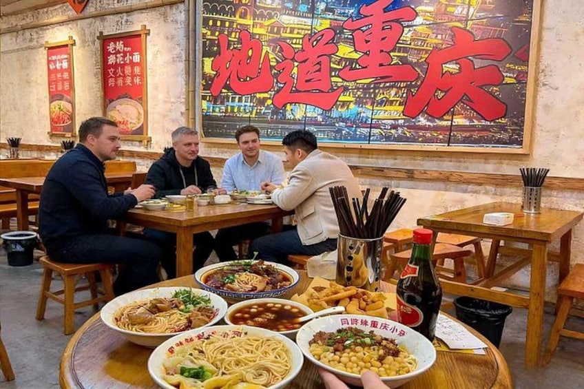 A group of people dining at a restaurant with various dishes on the table. 2