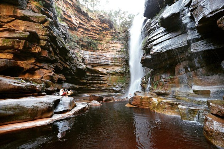 A waterfall in a rocky canyon with a pool at the base. 1