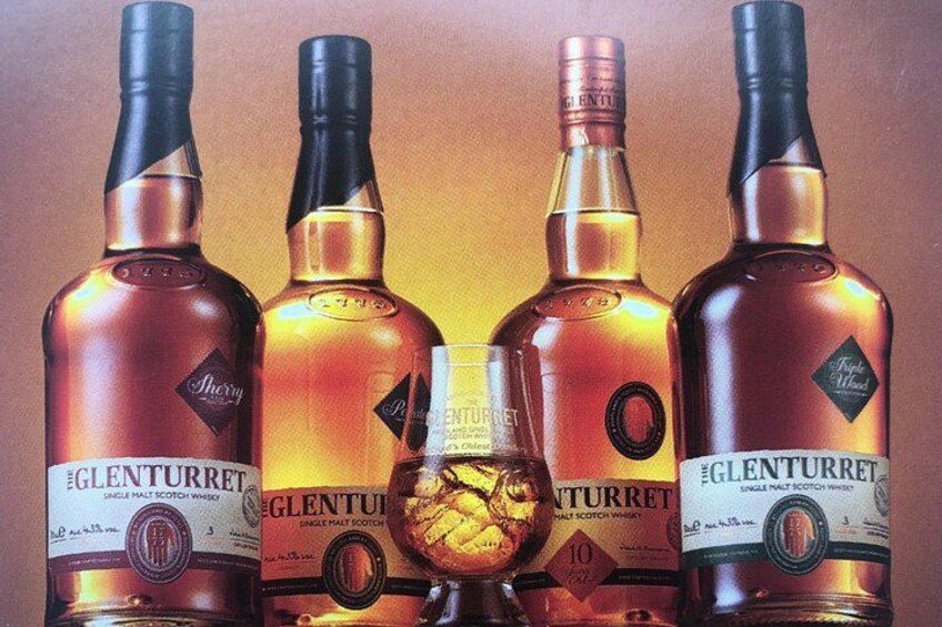 Five bottles of Glenfiddich whisky with a glass in the center. 4
