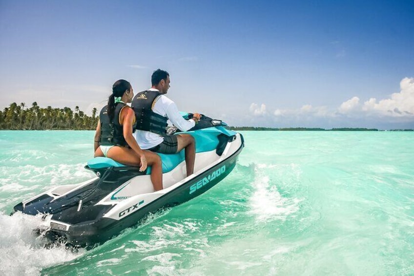 Un jet ski con due persone che si muove in acque turchesi. 2