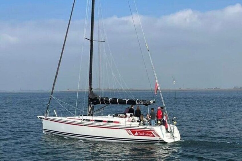 A sailboat named 'Sailforce' on calm waters with a clear sky. 4