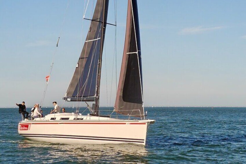 A sailboat with two sails on calm water. 1