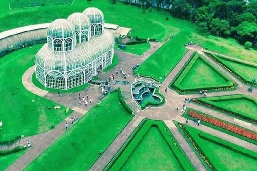 A large glass-domed structure surrounded by manicured gardens and pathways. 3