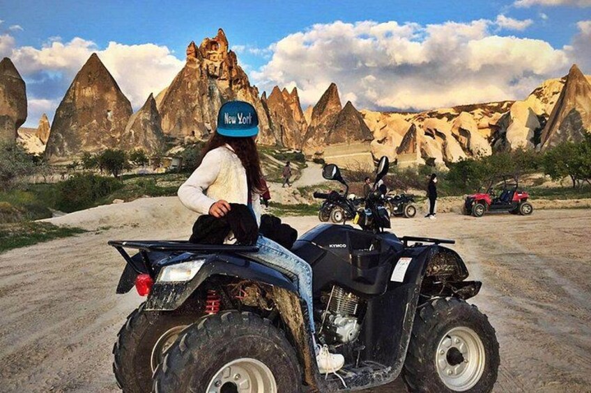 A person on an ATV in a desert landscape with rock formations. 4