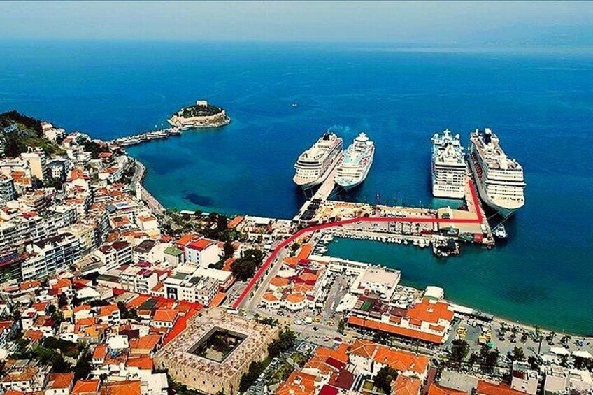 Una città costiera con un porto, navi da crociera ormeggiate e un'imponente fortezza storica. 2