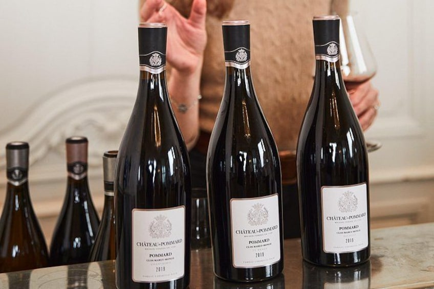 Several bottles of Château-Pomard wine on a table. 2