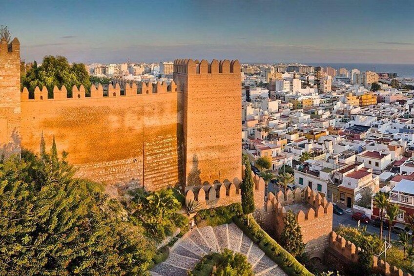 Muralla histórica con torres, edificios urbanos densos y cielo despejado. 1