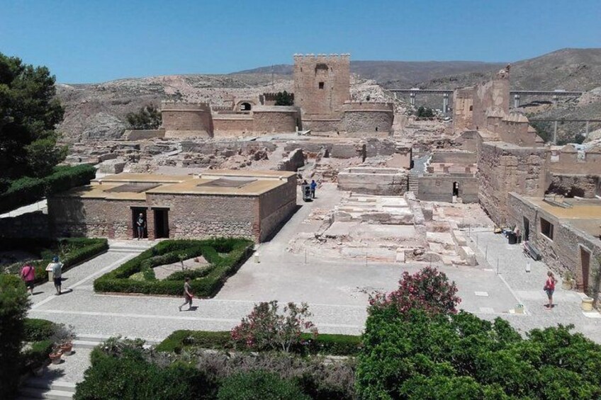 An ancient archaeological site with ruins, pathways, and a tower. 4