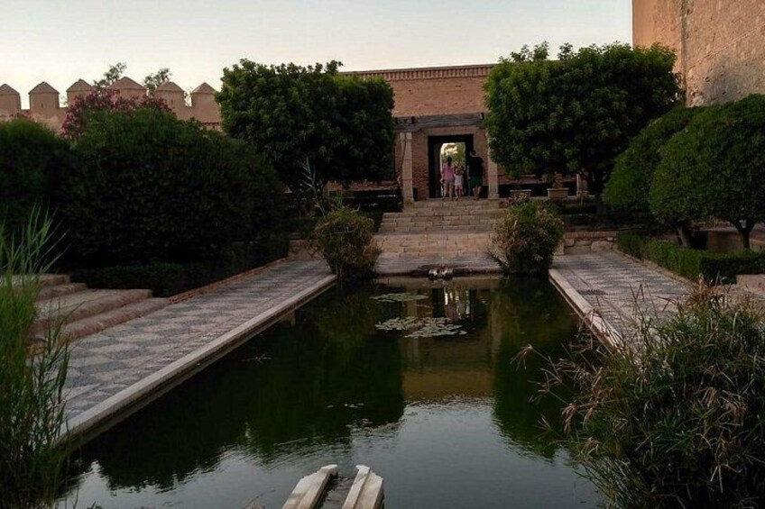 Un patio tranquilo con una fuente, un puente y la entrada a un edificio. 4