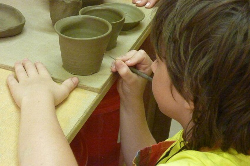 A person shaping clay on a pottery wheel. 1