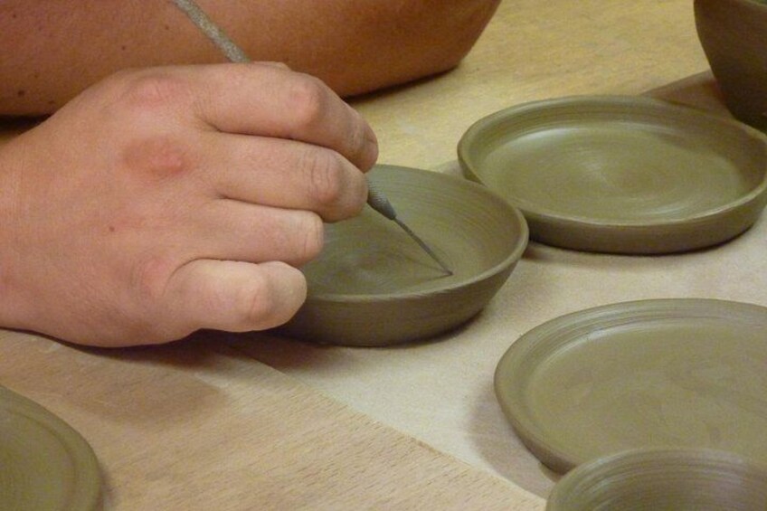 A person shaping clay on a pottery wheel. 4