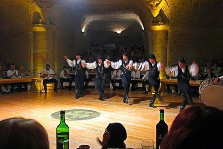 Un groupe interprète une danse traditionnelle sur une scène, devant un public assis. 5