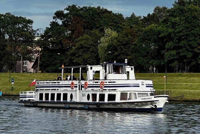 A white riverboat with the name 'HORIZONT' on its side, floating on calm water. 3