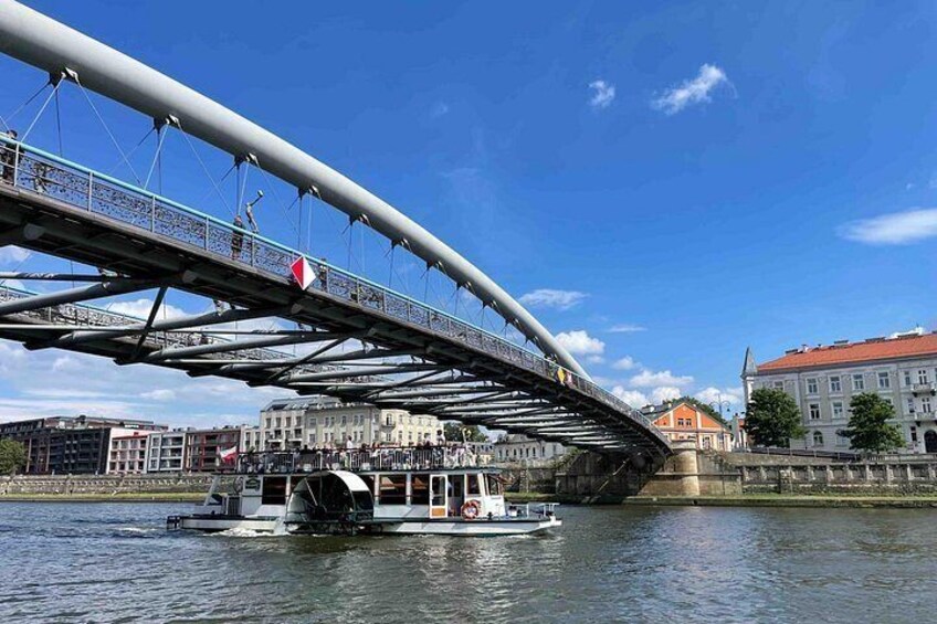 A bridge over water with a boat and buildings in the background. 4